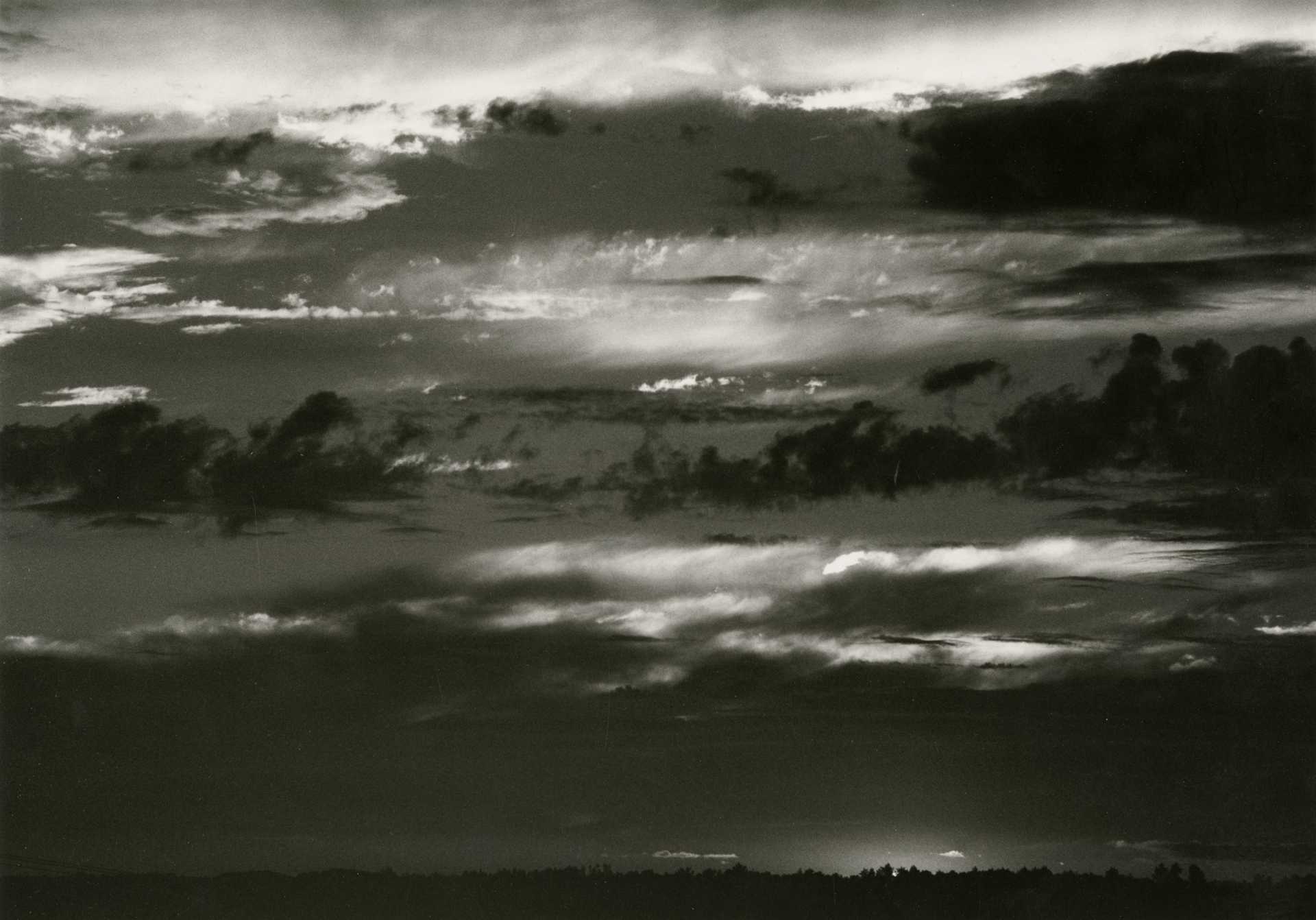 Schwarzweiß-Fotografie eines Wolken- und Lichtspiels am Himmel